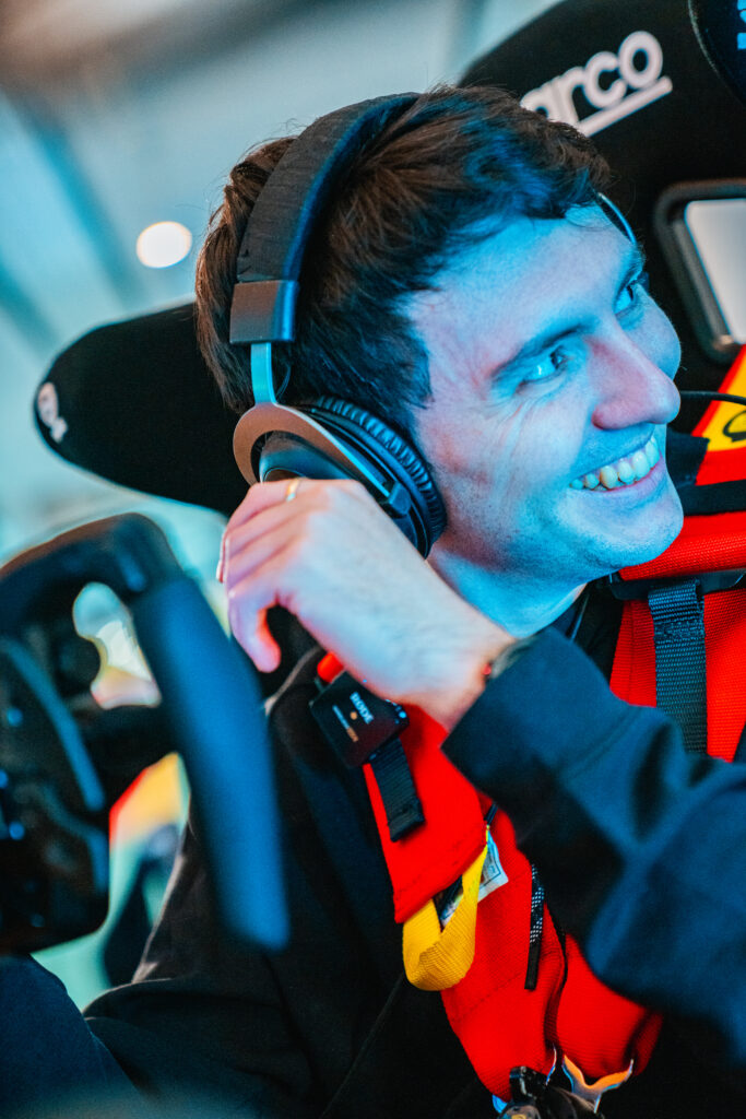 Fahrer mit Headset im Schalensitz des Rennsimulators