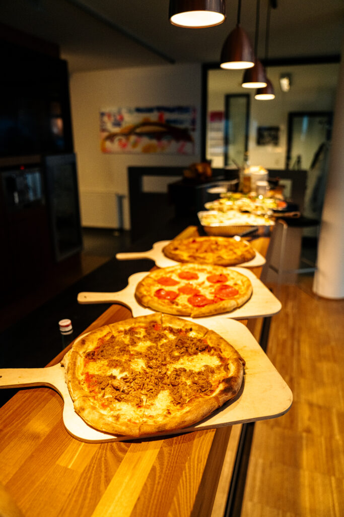 Frisch belegte Pizzen auf der Theke beim Event