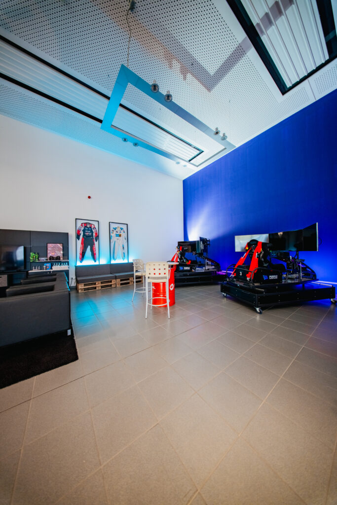 Racing-Lounge mit blauer Beleuchtung und Full-Motion-Simulatoren