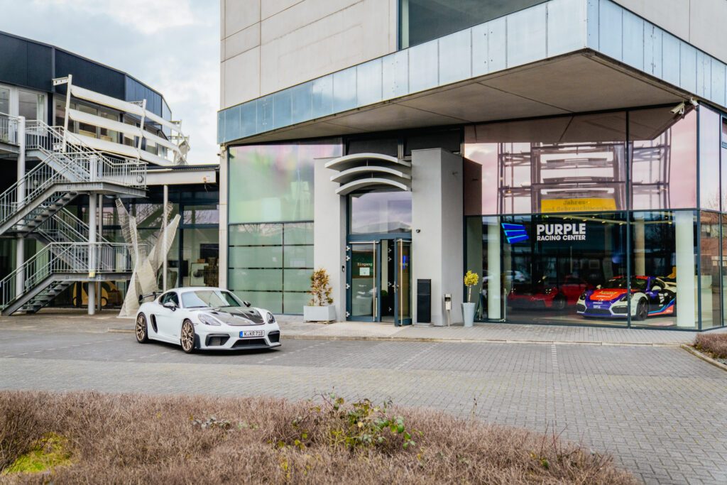 Außenansicht des Purple Racing Center in Köln-Marsdorf mit Sportwagen