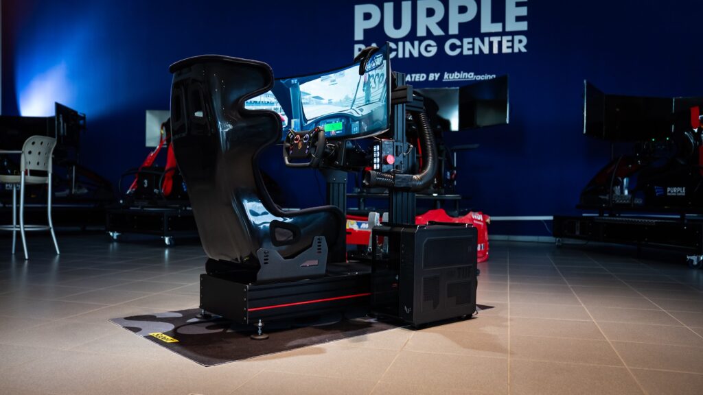 Rennsimulator vor der beleuchteten Purple-Racing-Center-Wand