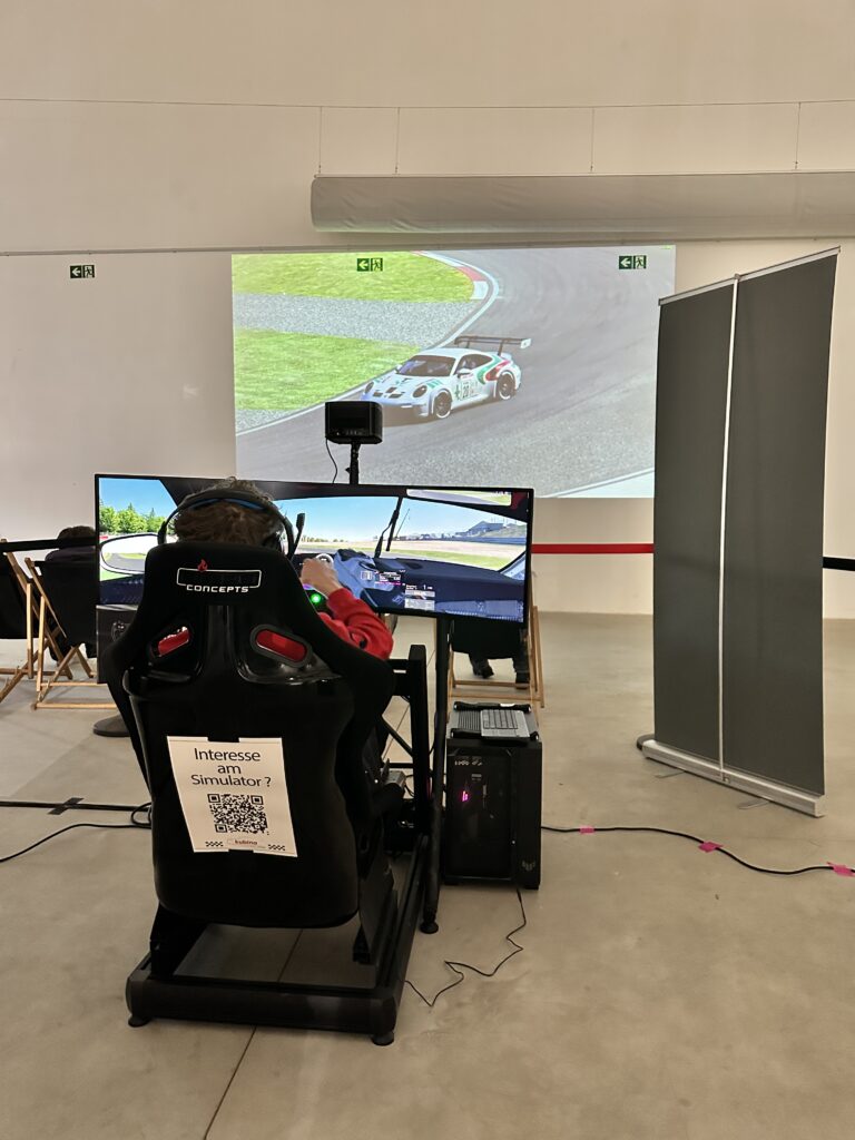 Rennsimulator vor einer Leinwand bei einer Veranstaltung