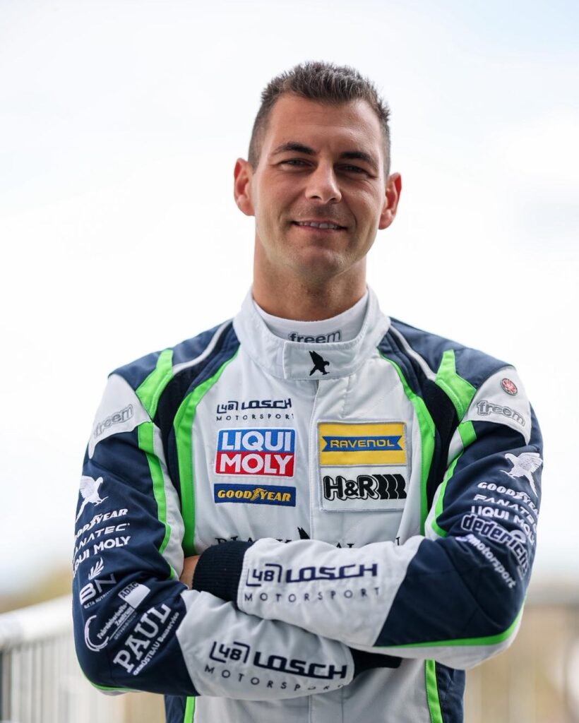 Porträt von Rennfahrer Tobias Müller im Rennanzug Purple Racing Center